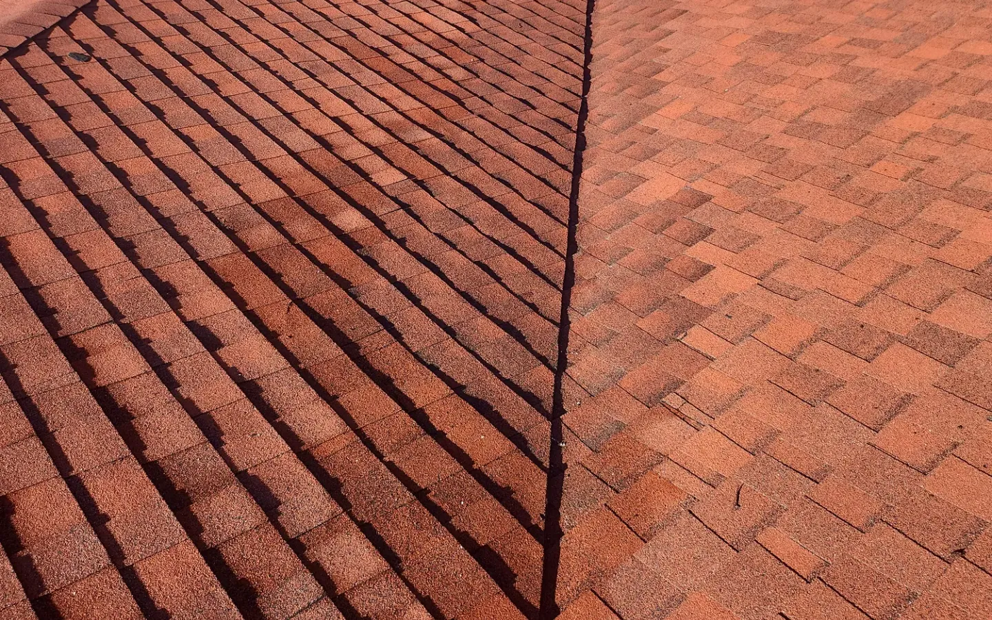 Red architectural shingle roof with a valley
