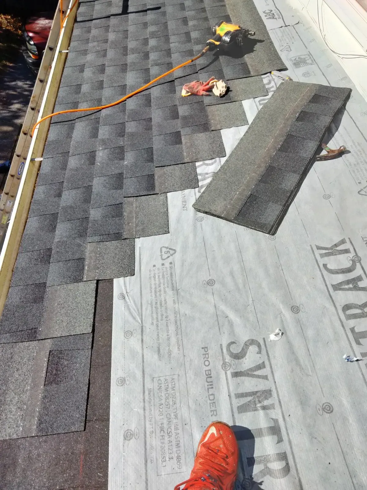 Shingles being nailed down on a new roof